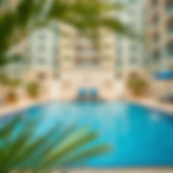 An inviting community pool area in a Nad Al Hamar apartment complex.